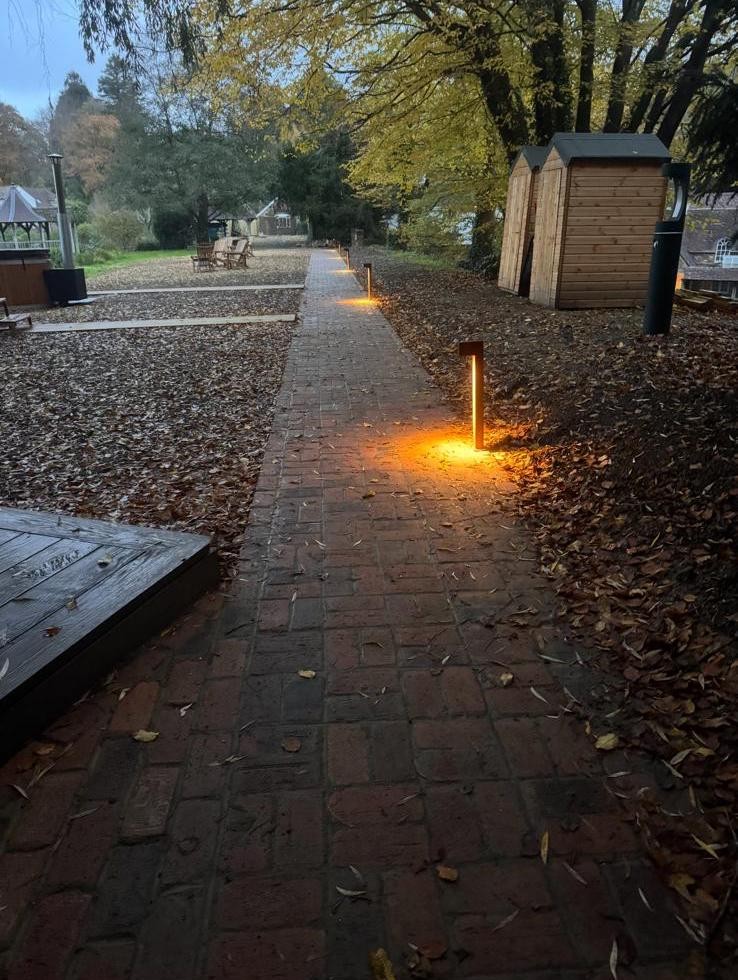 Brick path beside a pond and woodland area